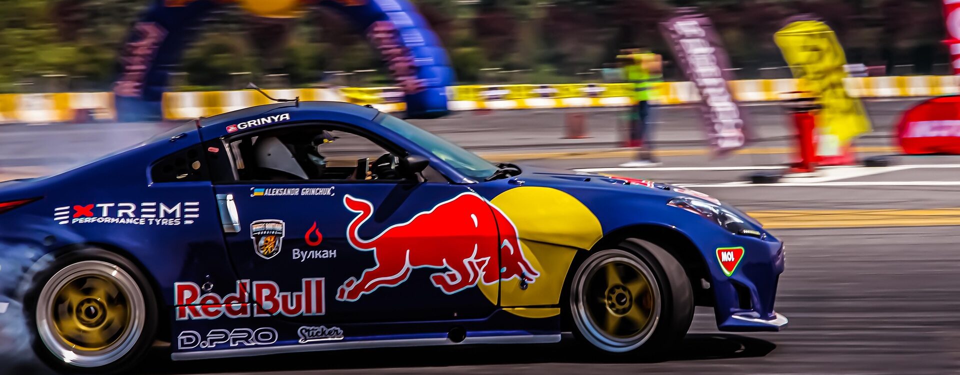 Voiture de drift sponsoris&eacute;e par Red Bull effectuant une figure sur circuit lors d'un &eacute;v&eacute;nement automobile