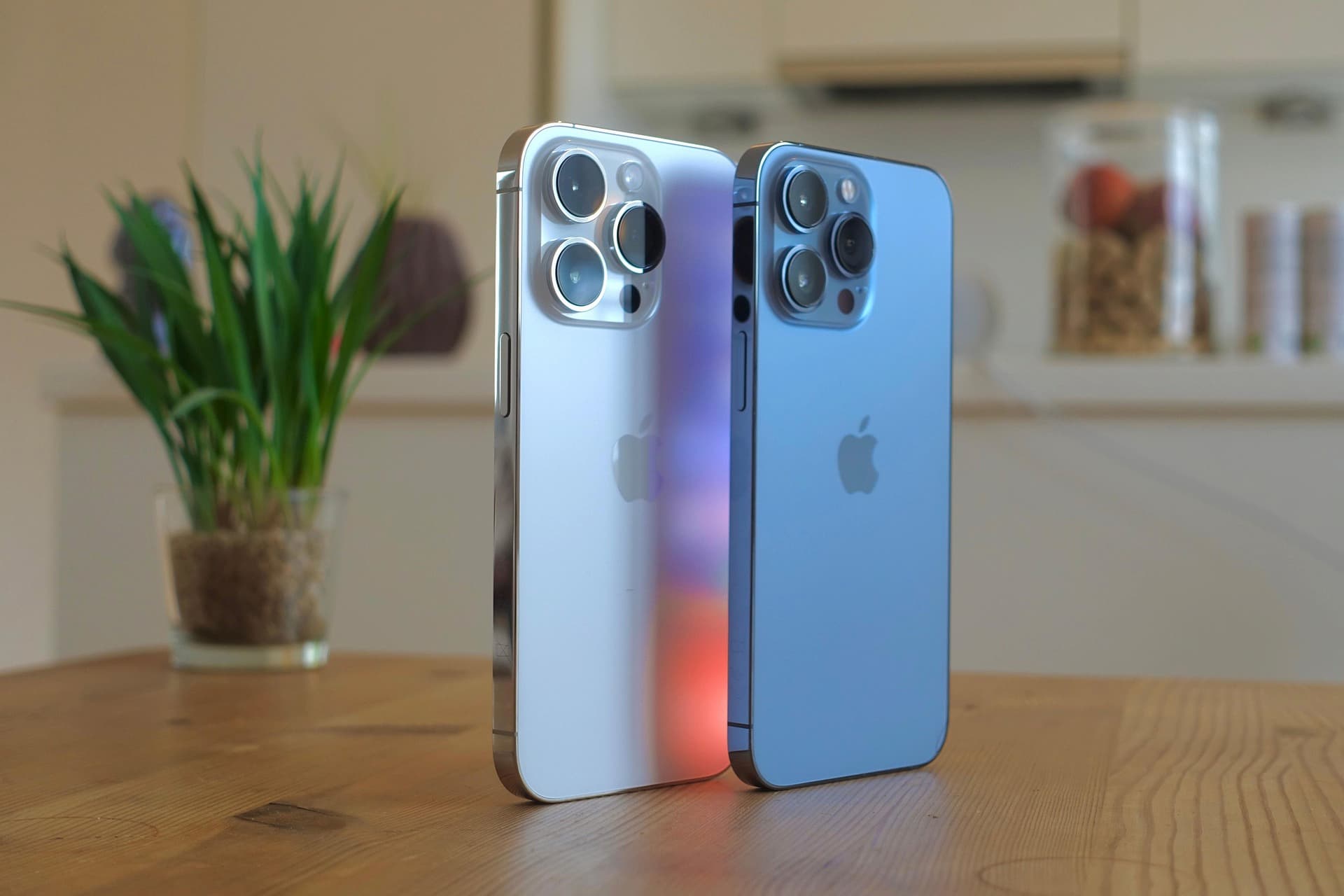 IPHONES 7479304_1920 1 | Cekome Deux iPhones modernes côte à côte sur une table en bois, un argenté et un bleu, avec arrière-plan flou