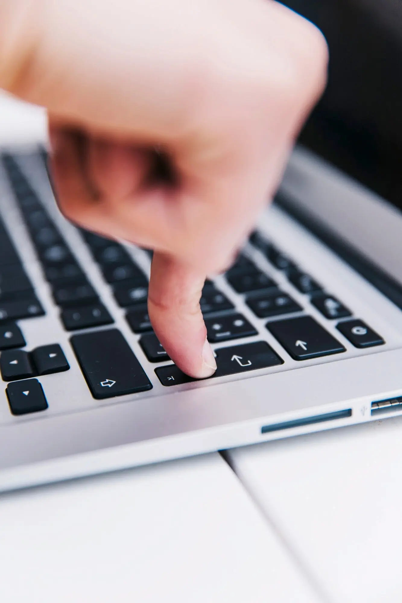 Gros plan d&rsquo;un doigt appuyant sur la touche Entr&eacute;e d&rsquo;un clavier d&rsquo;ordinateur portable, illustrant une action de validation ou de saisie num&eacute;rique.