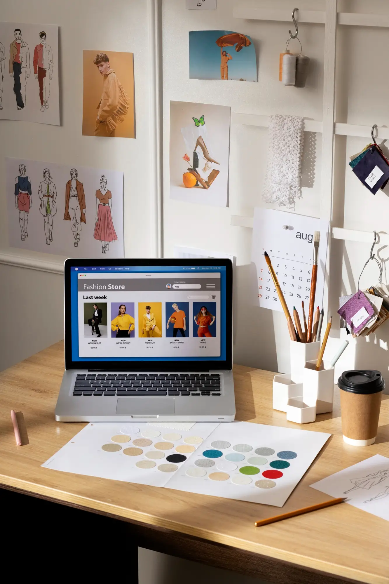 2151273068 | Cekome Espace de travail dédié à la création d’une boutique en ligne de mode avec maquettes, nuancier de couleurs et ordinateur affichant une interface e-commerce.