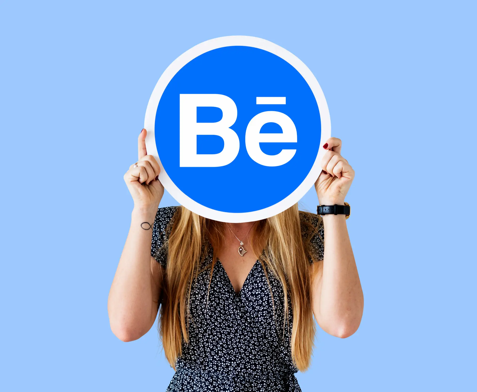 64899 | Cekome Logo Behance tenu devant une personne sur fond bleu