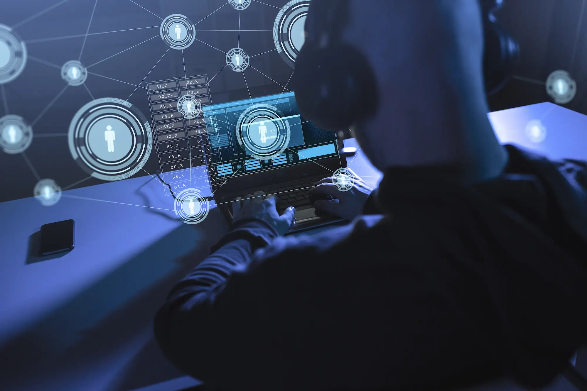 ADOBESTOCK_262197752 | Cekome Expert en cybersécurité analysant des données utilisateurs sur ordinateur portable avec visualisation de réseau et gestion des identités numériques