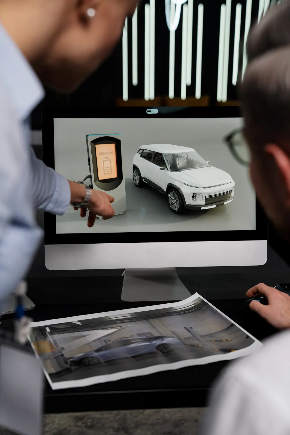 2149307818 | Cekome Présentation sur écran d’un modèle de voiture électrique et borne de recharge lors d’une réunion de conception digitale